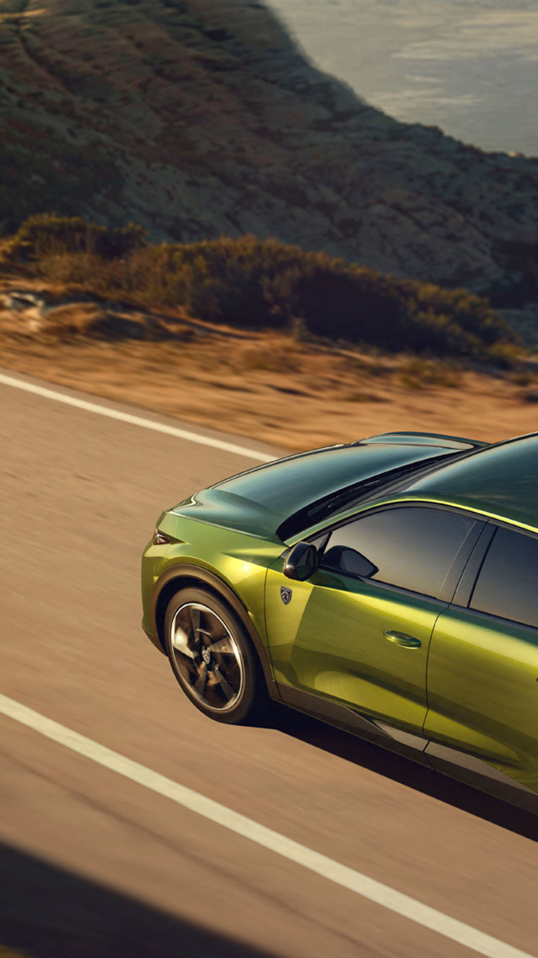 New PEUGEOT E-408 on a road by the sea