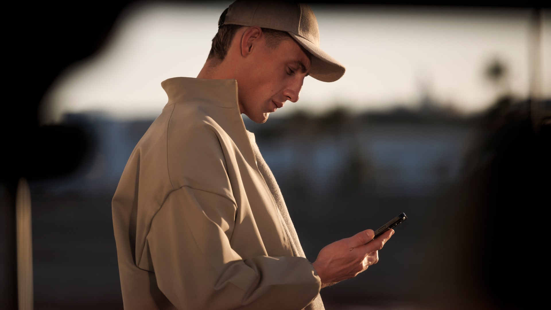 Uomo con uno smartphone e PEUGEOT E-5008